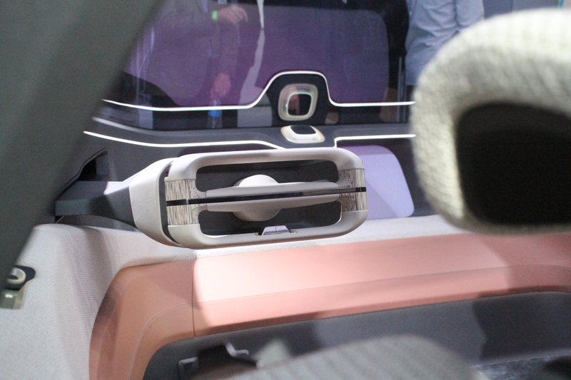 Very concepty steering wheel, with the Nomi AI square on the dashboard behind it. Photos and reporting from Stef Schrader for Jalopnik